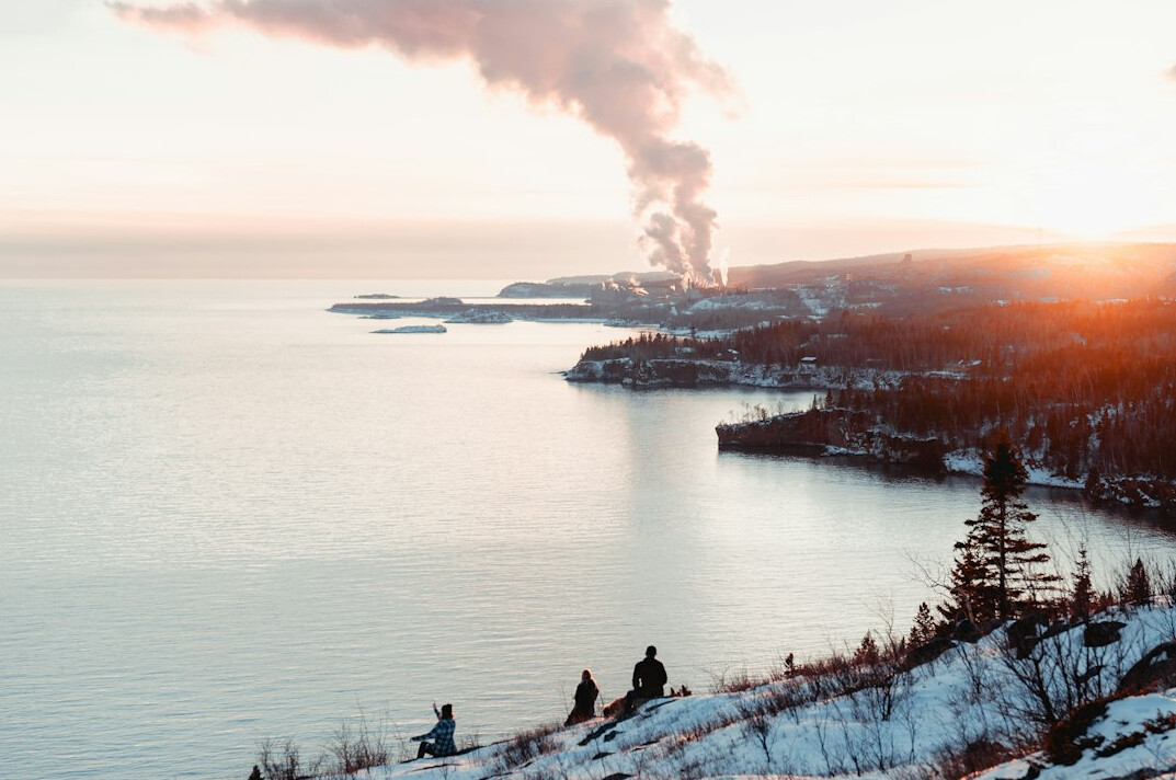 Industrial factory chimneys releasing smoke near the coast